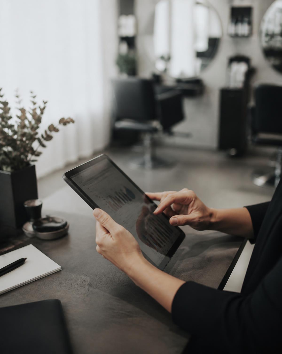Salon owner reviewing operating performance on a tablet